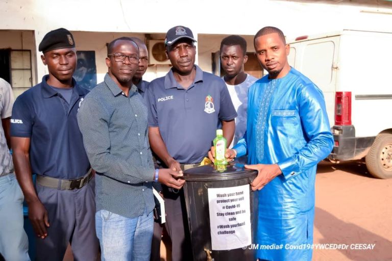 Dr Ceesay and youths in WRC distribute  plastic  buckets amid  public  sensitisation on Coronavirus